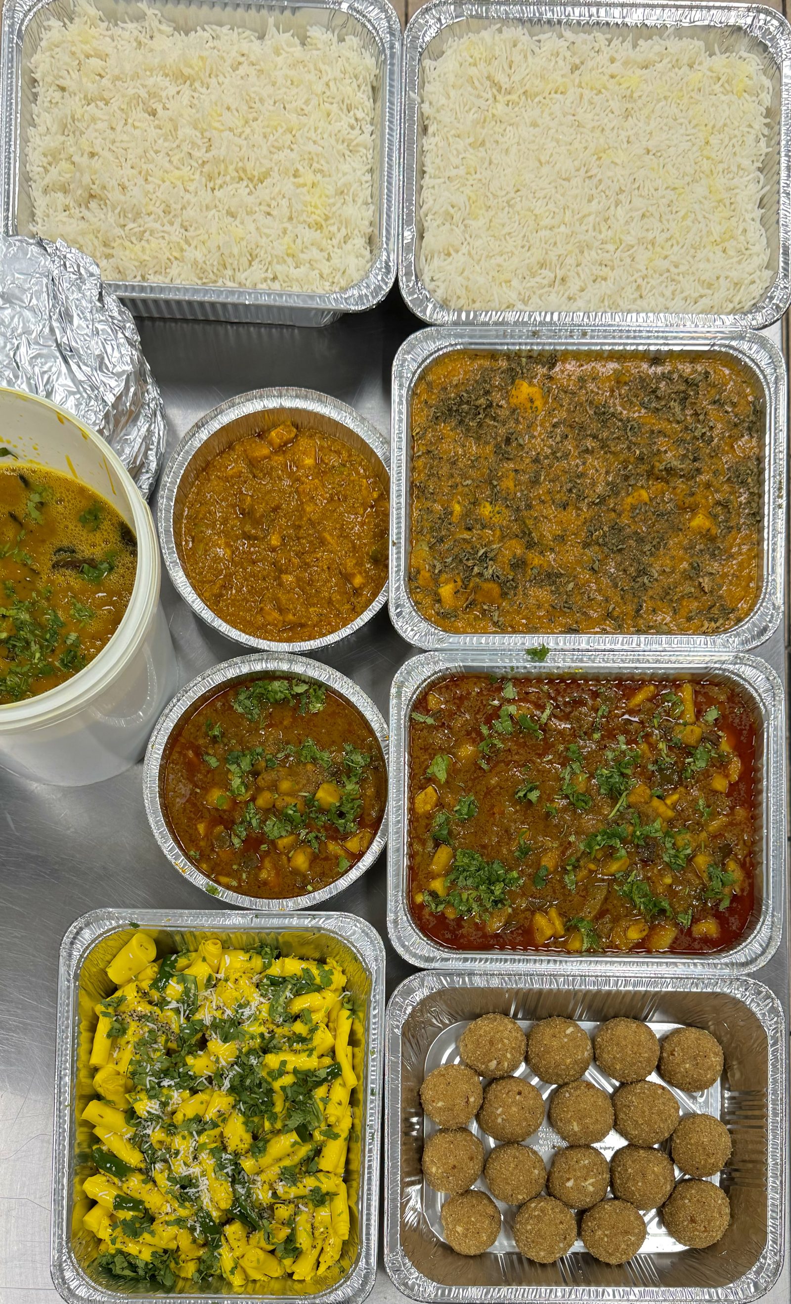 Compartment thali boxes filled with a full Gujarati meal