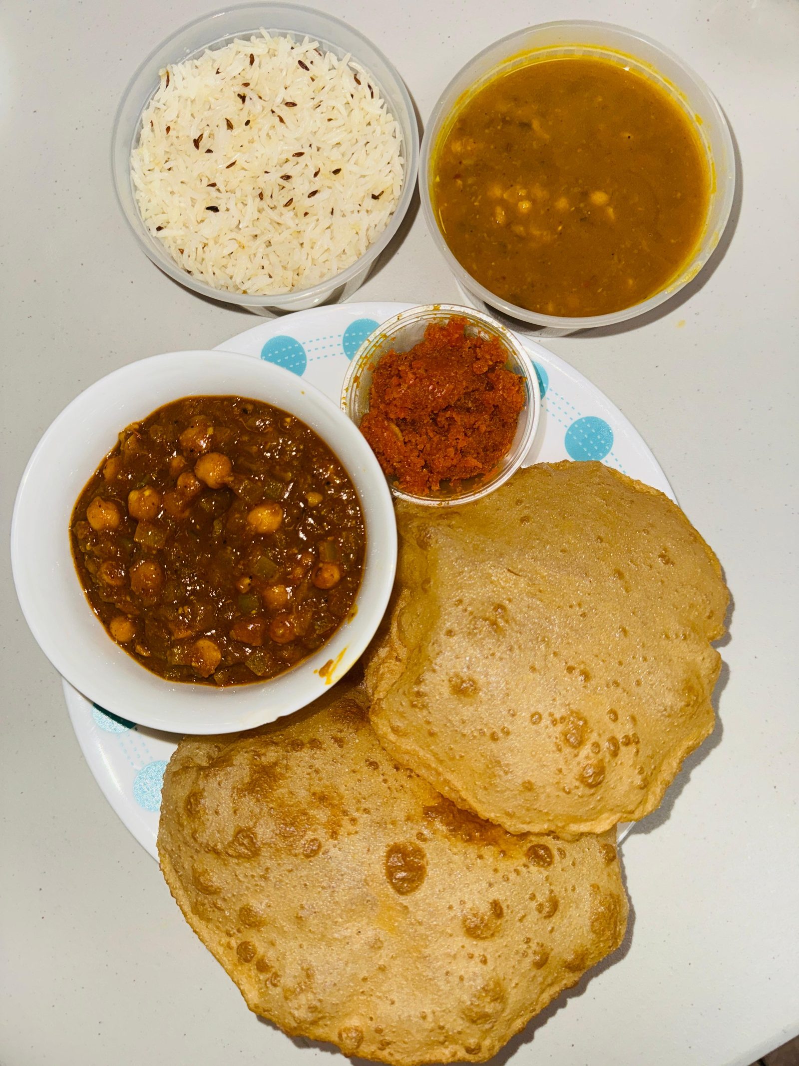 A full Gujarati thali: puri, chana, dal, rice and pickle